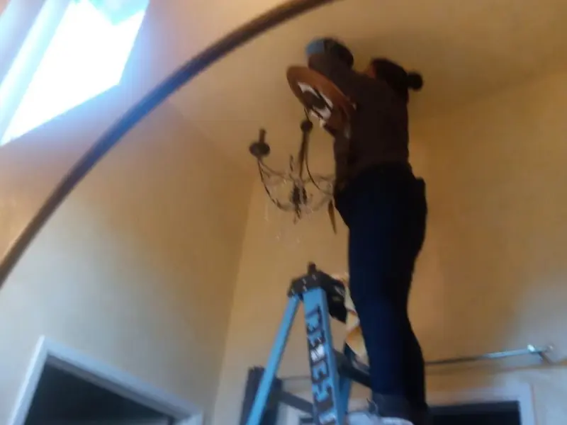 Electrician installing a chandelier in a Silver Creek residence
